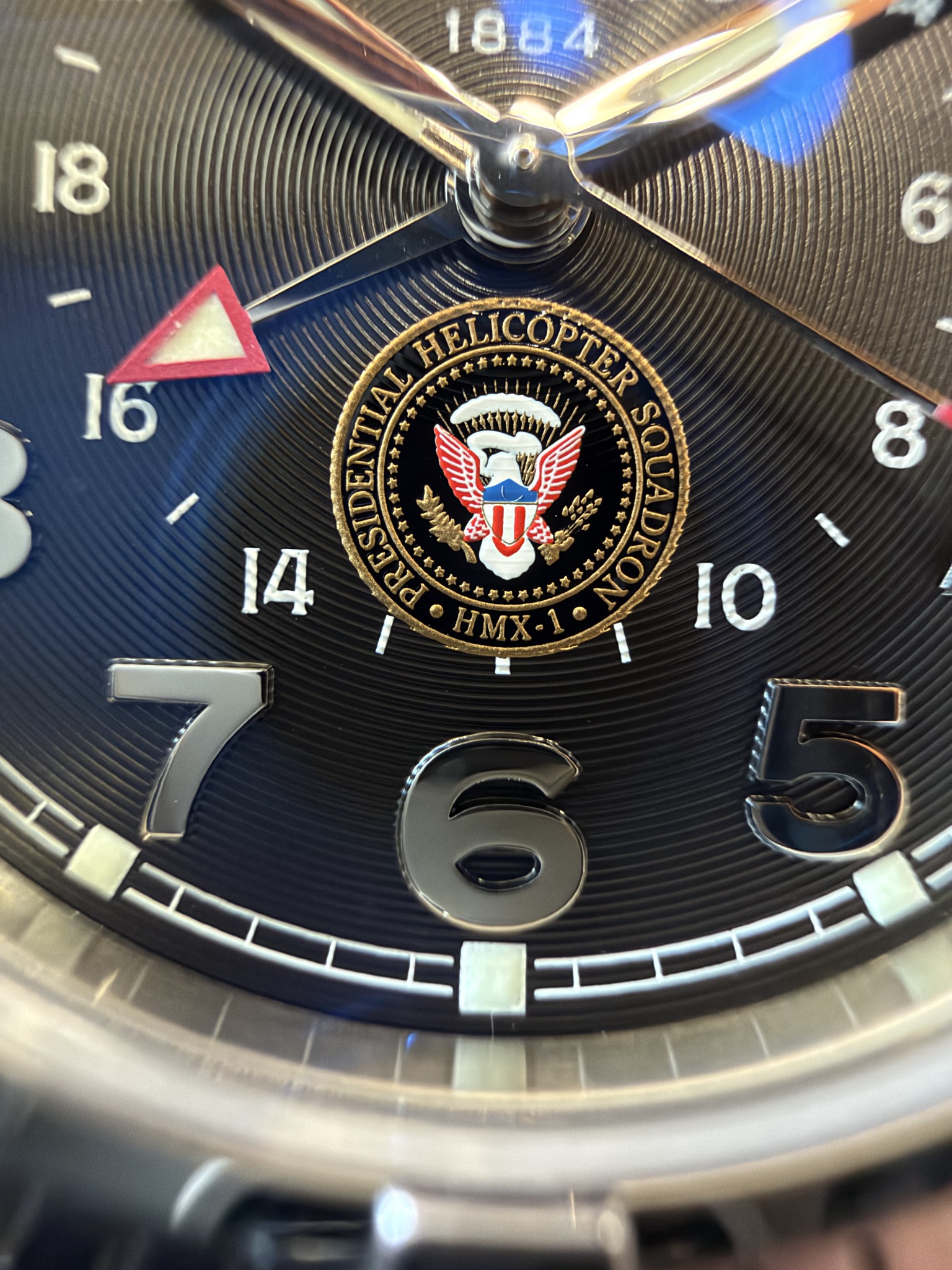 Original close-up photograph of the HMX-1 insignia above six o’clock, showing its gold lettering, eagle and the concentric black dial